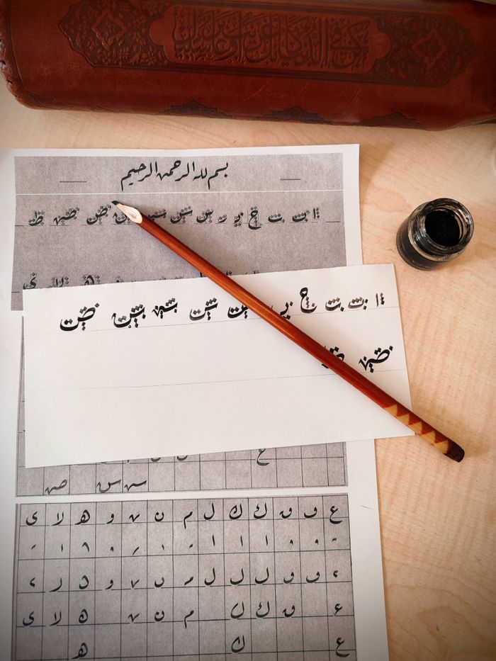 Explore traditional calligraphy with ink and brush in this artistic setup, showcasing elegant handwritten script.